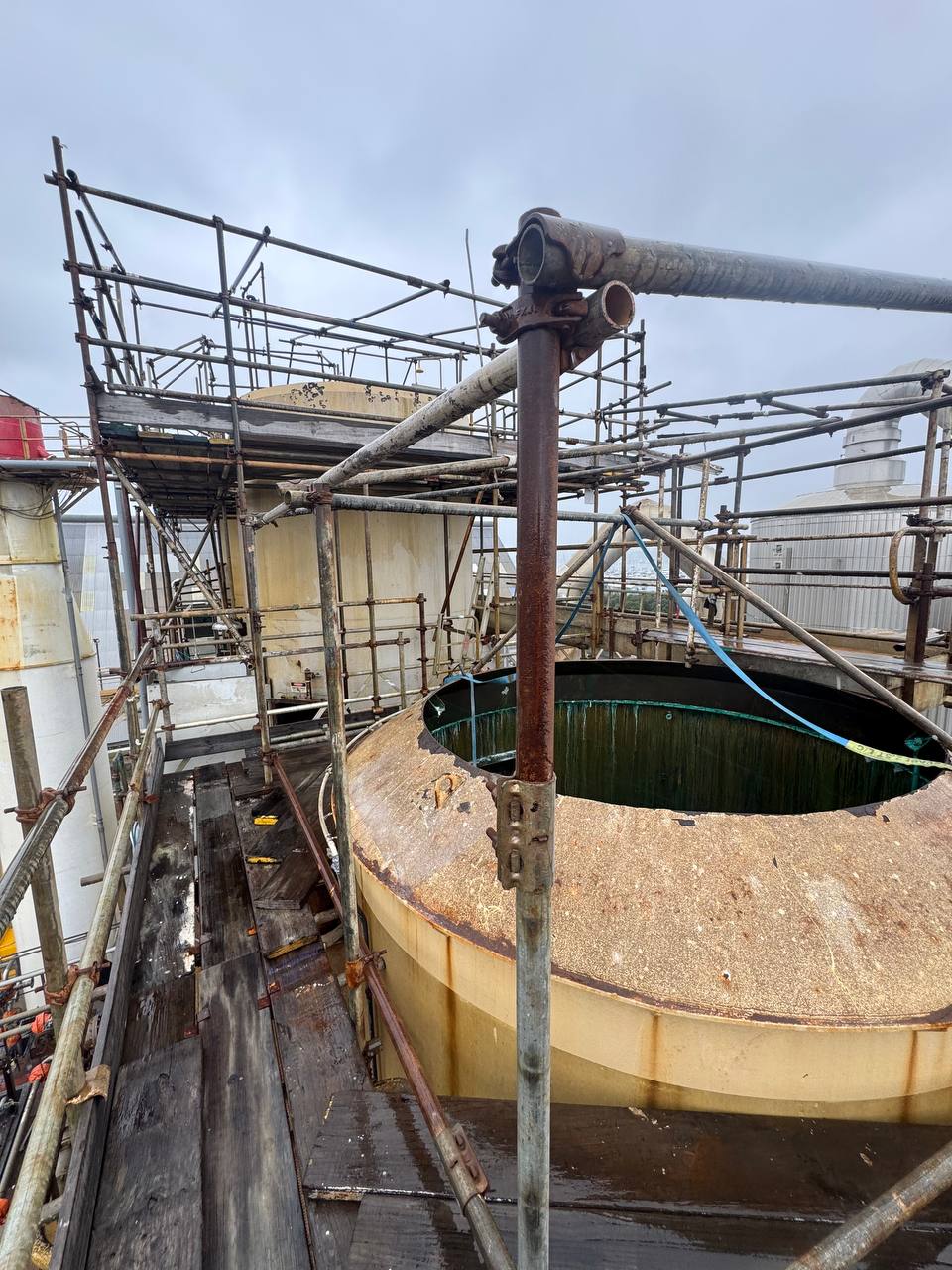 Safety scaffolding is erected around drying towers to provide safe access for asbestos removal.